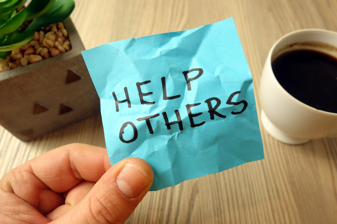 Help others - motivational reminder handwritten on sticky note